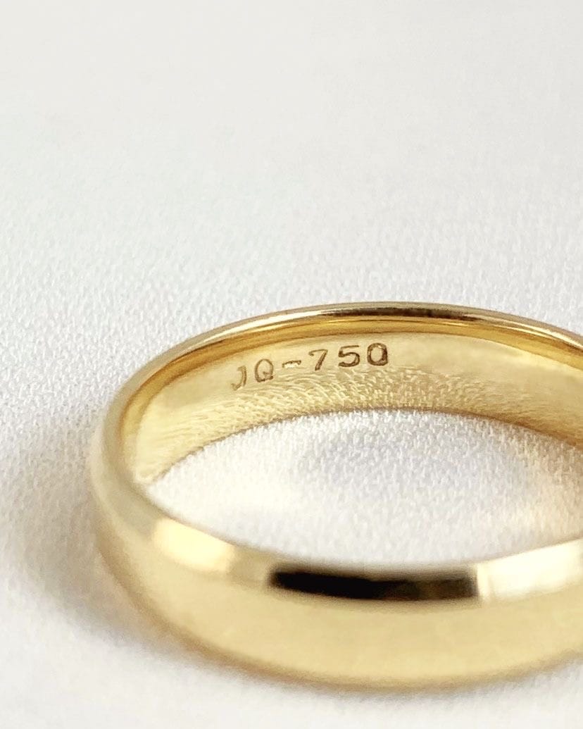 Ampliação do carimbo JQ 750 gravado no interior de uma aliança de ouro 18K